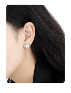 Close-up of a model wearing a S925 silver pearl stud earring with sparkling diamond halo