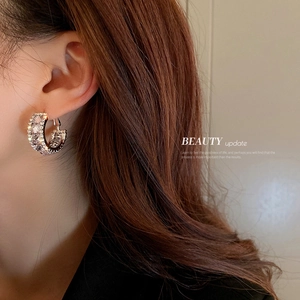 Silver-plated geometric C-shaped hoop earrings with sparkling cubic zirconia on model
