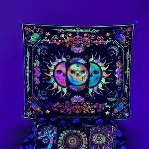 Detail of UV reactive tapestry featuring neon skull, butterfly, and moon on a purple wall