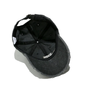 Detail of vintage washed baseball cap with distressed brim and adjustable metal buckle