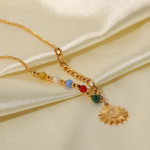 Detalle de collar de titanio de 18K con colgante de sol y cuentas de piedras de colores