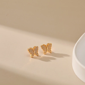 Detailed macro view of 18K gold butterfly earrings with micro-pave white zircon stones