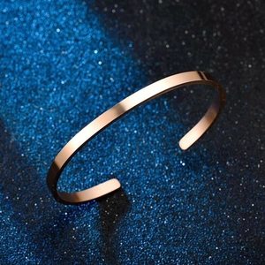 Polished rose gold stainless steel C-shaped cuff bracelet on a starry blue background