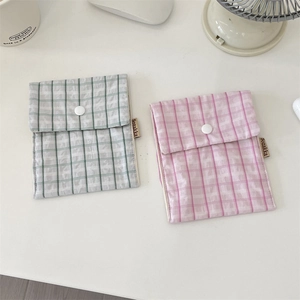 Detail of floral and plaid sanitary napkin storage pouches with snap button closure