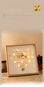 Macro detail of DIY shell heart picture frame with warm LED night light illumination