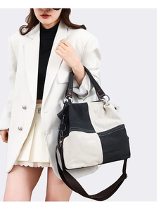 Detail of a large black and white canvas tote bag with adjustable shoulder straps