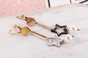 Détail de boucles d'oreilles pendantes en acier étoilé avec perles en plusieurs finitions