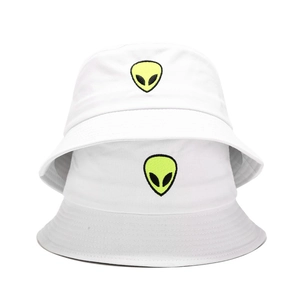 Close-up of high-quality cotton fabric with yellow alien head embroidery on white bucket hats