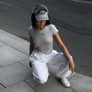 Détail d'un t-shirt de sport gris ajusté et d'un pantalon de jogging blanc décontracté
