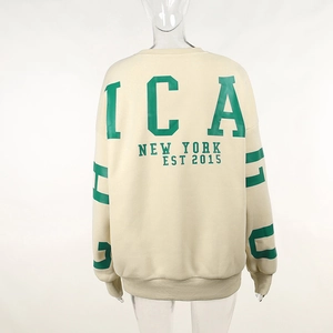 Détail de l'inscription verte ICA NEW YORK au dos du sweat-shirt oversize en polaire crème