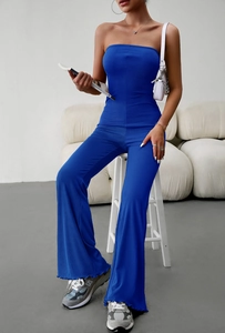 Detail of navy knit strapless jumpsuit featuring elegant flared legs and ruffle hem