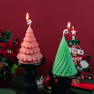 Detail of lit spiral and wave pattern Christmas tree candles on black matte stands