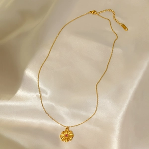 Gold stainless steel flower pendant necklace with rose red zircon on white satin