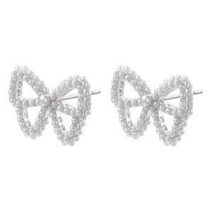 Detailed view of silver bow-shaped stud earrings with inlaid white pearls on white background