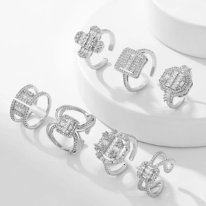 Set of seven silver open rings with zircon stones on white minimalist stands