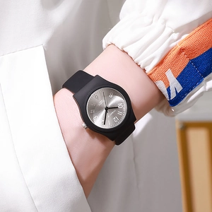 Close-up of minimalist black quartz watch with sunray dial and large Arabic numerals