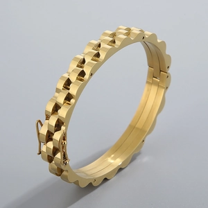 Détail du bracelet en acier inoxydable doré avec bords festonnés et fermoir pliable