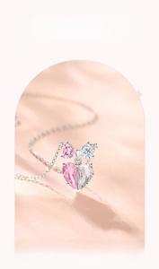 Detailed macro view of 925 sterling silver bow pendant with pink heart-shaped zircons