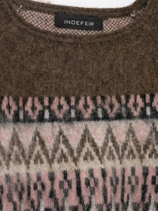 Detail view of round neck knitwear showing geometric jacquard and fuzzy fabric texture