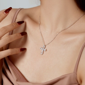 Close-up of S925 silver cross pendant necklace with zircon stones on model collarbone