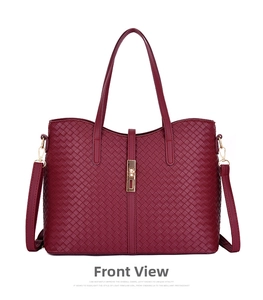 Détail d'un sac cabas tissé bordeaux avec texture tressée et boucle en métal doré