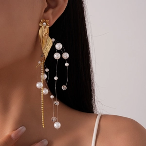 Detail of vintage gold flower earrings with pearls and crystals on a female model