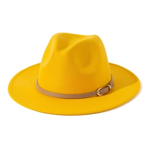 Detail of a bright yellow fedora hat with a brown leather belt strap and gold buckle