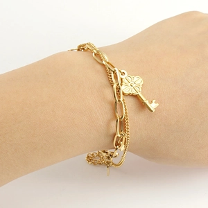 Multi-layer 18k gold plated stainless steel bracelet featuring a floral key pendant