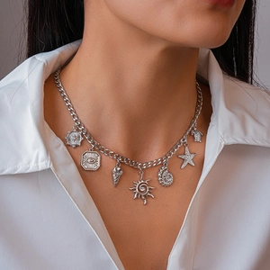 Detail of silver-tone chunky chain necklace with seashell and starfish charms on a model