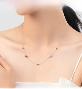 Dettaglio della collana in argento S925 con quattro zirconi rossi e rosa sulla modella