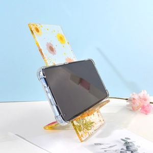 Detail of DIY epoxy resin phone stand with real dried flowers and gold foil accents