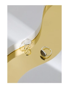 Macro shot of two S925 sterling silver moonstone rings on golden mirror surface