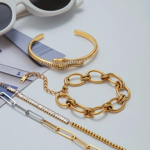 Gros plan du bracelet serpent doré serti de diamants et gourmettes à maillons épais
