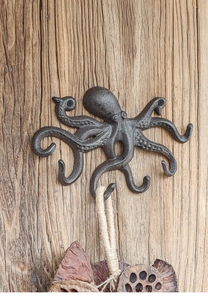 Detail eines Oktopus-Wandhakens aus Gusseisen auf rustikalem Holzuntergrund