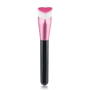 Detail of heart-shaped foundation brush with pink gradient soft bristles and black handle