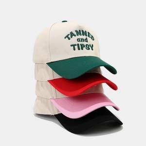 Stacked two-tone cotton baseball caps with TANNED and TIPSY embroidery in various colors