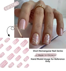 Kurze eckige künstliche Nägel mit weißen Blattmustern und Goldfolie auf Nude-Rosa