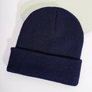 Gros plan d'un bonnet en maille bleu marine avec texture côtelée et bord replié classique