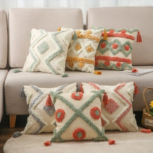 Bohemian tufted cushion covers with tassels and embroidery on a beige sofa