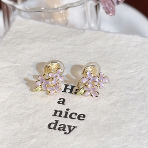 Close-up of purple flower earrings with silver needles and exquisite enamel oil detail