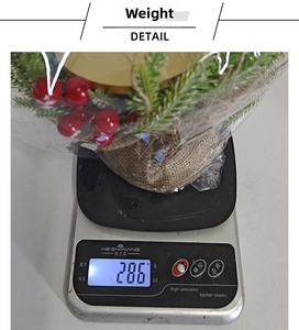 Detail shot of Christmas berry wreath candle holder on scale weighing 286 grams