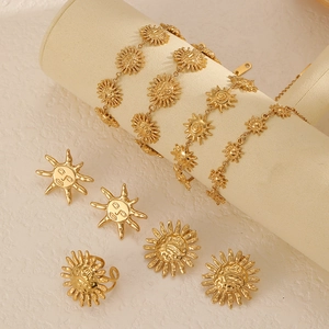 Golden sun jewelry set featuring earrings, bracelets and rings on a beige velvet stand