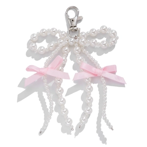 Detail view of a white pearl beaded keychain featuring pink ribbons and silver lobster clasp
