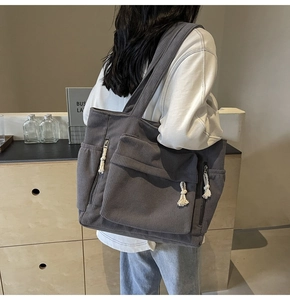 Détail du sac fourre-tout en velours côtelé gris foncé avec poches et tirettes en corde