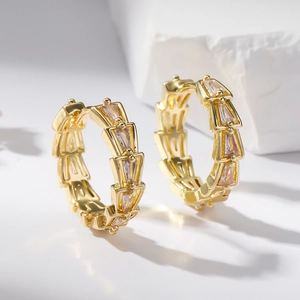 Gold plated hoop earrings with geometric clear zircon stones on a white background