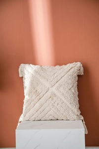 Detail of cream Moroccan tufted cushion cover with geometric patterns and fringe