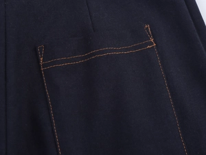 Detail of contrast orange stitching on dark navy cotton pocket with twill texture