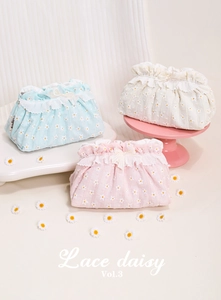 Detailed view of floral lace makeup bags with daisy embroidery in three soft pastel colors