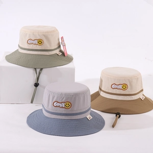 Close-up of embroidered smiley face patch and cotton canvas texture on kids bucket hats