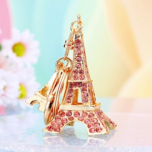 Macro shot of gold metal Eiffel Tower keychain featuring pink rhinestones and hook detail